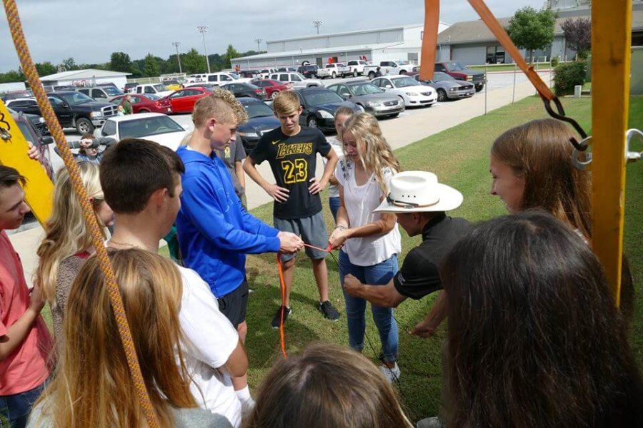 Grove, OK: Students and staff use friction to slice through a climbing rope with a string during a physics demo